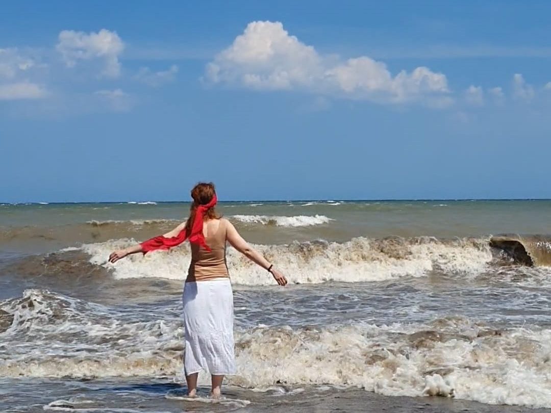 Liilia Link an einem sonnigen Strand mit Blick auf Meereswellen
